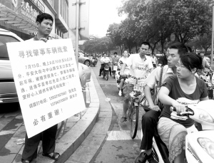 小康的亲属手举牌子站在事发地点寻找线索。张海强摄