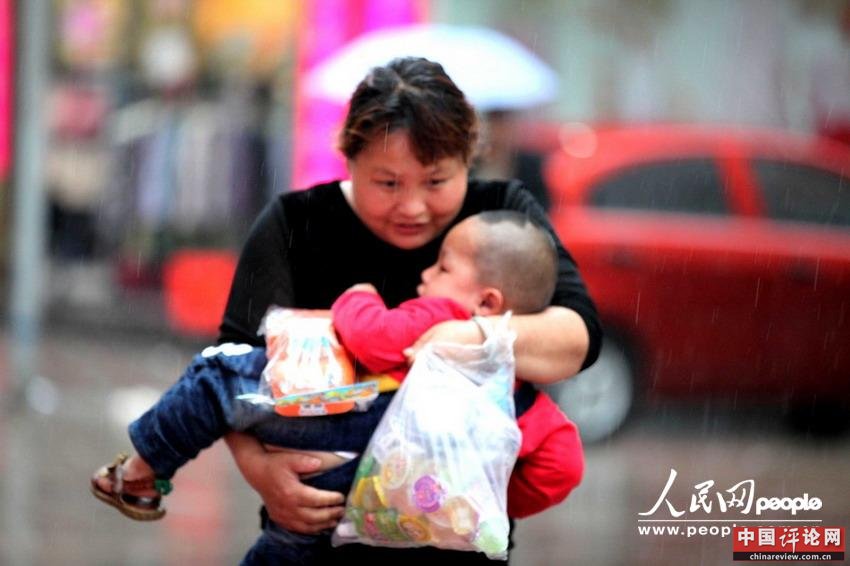 2013年5月26日，行人冒雨在安徽亳州市出行。金镜头/东方IC 